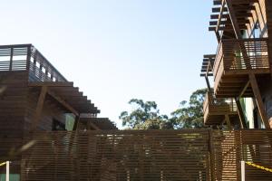 a building with a wooden fence in front of it at Local da Lagoa Chalés e Lofts in Imbituba