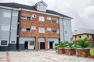 a large brick building with white windows at Schemes Hotel And Apartment in Port Harcourt