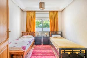 two beds in a room with a window at Haddad's for families in Tangier +46 photos