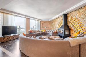 a living room with a large couch and a fireplace at Haddad's for families in Tangier