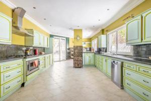 een grote keuken met gele en groene kasten bij Haddad's for families in Tanger