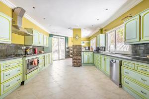 a large kitchen with yellow and green cabinets at Haddad's for families in Tangier