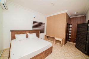 a bedroom with a bed and a dresser at Schemes Hotel And Apartment in Port Harcourt
