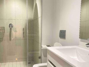 a bathroom with a shower and a toilet and a sink at Views on the six in Midrand