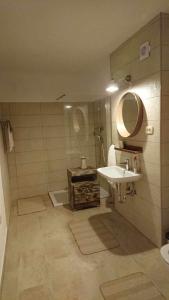 La salle de bains est pourvue d'un lavabo et d'un miroir. dans l'établissement Kraska nisa, à Komen