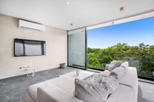 a living room with a couch and a large window at Kite 201 in Tulum