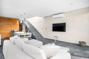a living room with a white couch and a tv at Kite 201 in Tulum