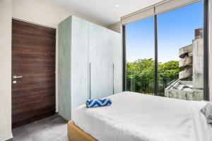 a bedroom with a large bed and a large window at Kite 201 in Tulum +14 photos