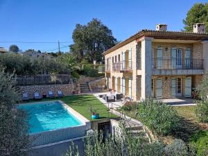 a house with a swimming pool in front of it at Bastide d'Architecte en Pierre in Cagnes-sur-Mer
