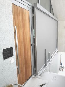 a bathroom with a mirror and a wooden door at Urban Alpine Penthouse with Lake View in Maurach