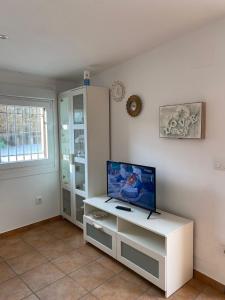 a living room with a tv on a white table at Apartamento Sant-Yago in Santiago de Compostela