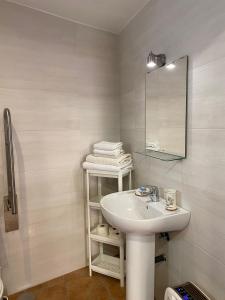 a white bathroom with a sink and a mirror at Apartamento Sant-Yago in Santiago de Compostela
