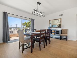 a dining room with a table and chairs and a large window at La Playa -Crown Point Bayside Luxury Condo in San Diego