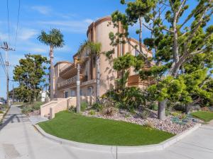 a house with palm trees in front of it at La Playa -Crown Point Bayside Luxury Condo in San Diego