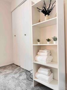 a shelf with towels and a mirror in a room at Cozy 3 bdr Retreat in a Prime location in Streamwood