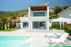 a villa with a swimming pool and a house at OFF White Villas in Vasiliki