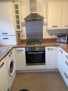 a kitchen with a stove and white cabinets at Pacific House in Thornaby on Tees