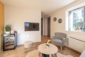 - un salon avec une table, une chaise et une télévision dans l'établissement Villa des Cygnes près du lac marina Grand Port, à Aix-les-Bains