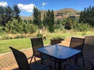 a blue table and chairs on a patio with a view at Stonehenge Clarens in Clarens