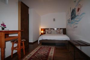 a bedroom with a bed and a desk in it at B&B Duo Caffe Baneasa in Bucharest