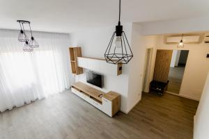 a living room with a flat screen tv and two lights at Samplus Central Apartment in Craiova