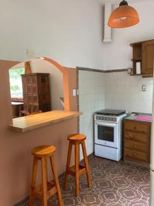 a kitchen with a stove and two stools in it at Casa Tejas in San Luis