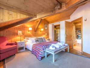 una camera da letto con un letto e una sedia rossa di Chalet 5* à Courchevel Village, proche pistes, 4 chambres, cheminée, jacuzzi, garage, Wi-Fi inclus - FR-1-562-40 a Courchevel