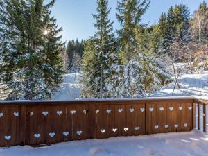 una recinzione ricoperta di neve con alberi sullo sfondo di Chalet 5* à Courchevel Village, proche pistes, 4 chambres, cheminée, jacuzzi, garage, Wi-Fi inclus - FR-1-562-40 a Courchevel