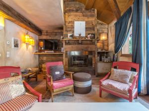 un soggiorno con sedie e un camino di Chalet 5* à Courchevel Village, proche pistes, 4 chambres, cheminée, jacuzzi, garage, Wi-Fi inclus - FR-1-562-40 a Courchevel