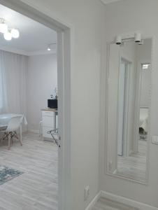 a white room with a mirror and a living room at 1-но комнатная квартира в центре Астаны ЖК Sezim Qala 4 in Astana