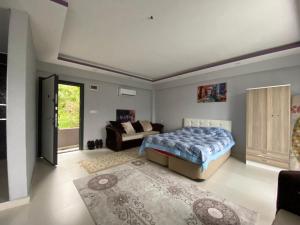 1 dormitorio con 1 cama y 1 sofá en yuvacik kazli bahçe bungalov & taş otel, en Yuvacık