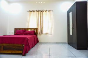 um quarto com uma cama com um cobertor vermelho e uma janela em PEACEFUL LIVING SUITE II em Cochin