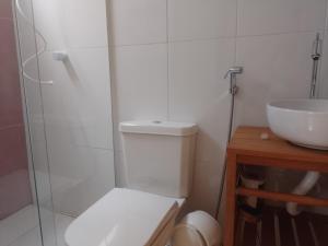 a bathroom with a toilet and a sink at Casa Perto Praia do Forte in Cabo Frio