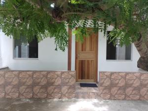 a door of a house with a tree at Casa Perto Praia do Forte in Cabo Frio