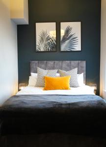 ein Schlafzimmer mit einem Bett mit zwei Bildern an der Wand in der Unterkunft Brighton City Centre 2 Bed Apt in Brighton & Hove
