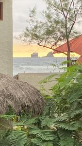 Malevo Suites - Apartments في أيامبي: لوحة على شاطئ مع كوخ من القش