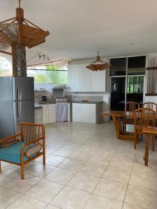 a kitchen with a refrigerator and a table and chairs at Malevo Suites - Apartments in Ayampe