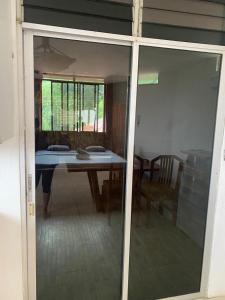 a glass door leading into a dining room with a table at Malevo Suites - Apartments in Ayampe