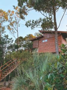 a wooden house on a hill with trees at Chalés Itapeva Ecovillage in Torres +31 photos