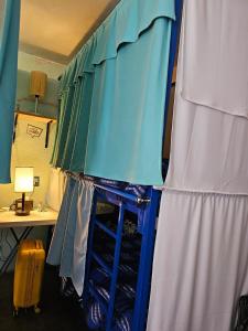a room with a blue and white curtain and a desk at Hostal Casa Amarilla Tecámac in Santa Cruz Tecamac