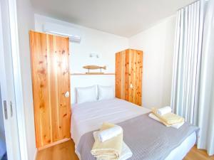 een kleine slaapkamer met een bed en houten kasten bij Pedra do Mar in São Roque