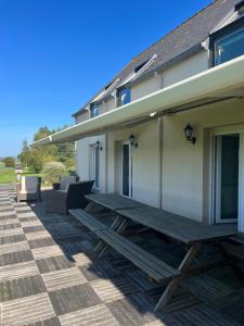 a picnic table on the side of a house at Le Moulin de la Butte in Huisnes-sur-Mer