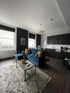 ein Wohnzimmer mit einem blauen Sofa und einem Tisch in der Unterkunft Brighton City Centre 2 Bed Apt in Brighton & Hove