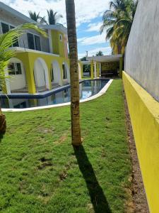 una palmera frente a un edificio con piscina en Chalet san marino en Colonia La Providencia