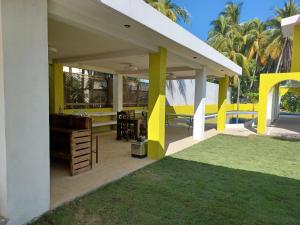 patio z żółtymi i białymi kolumnami i trawą w obiekcie Chalet san marino w mieście Colonia La Providencia
