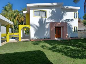una casa con un cortile verde davanti di Chalet san marino a Colonia La Providencia