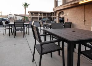 a row of wooden tables and chairs on a sidewalk at Travelodge by Wyndham Parker in Parker
