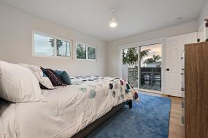 - une chambre avec un grand lit et un tapis bleu dans l'établissement Modern Dream Home - Fire Pit, Grill, Large Yard & AC, à Encinitas