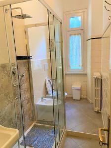 een badkamer met een douche, een toilet en een wastafel bij Villa Silvana in Perledo