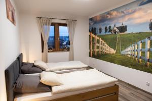 um quarto com três camas e um quadro na parede em Apartament Nad Stajnią em Krośnica